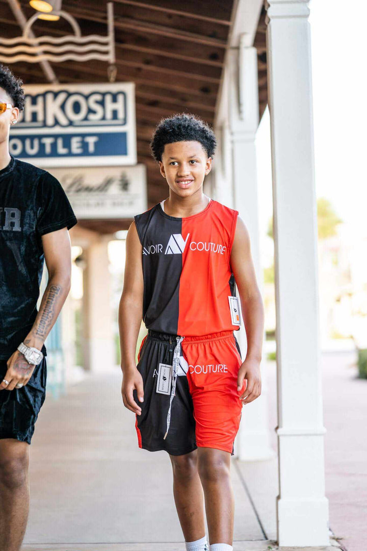 Boy wearing black and red 2pc Swim and Lounge Set walking outdoors